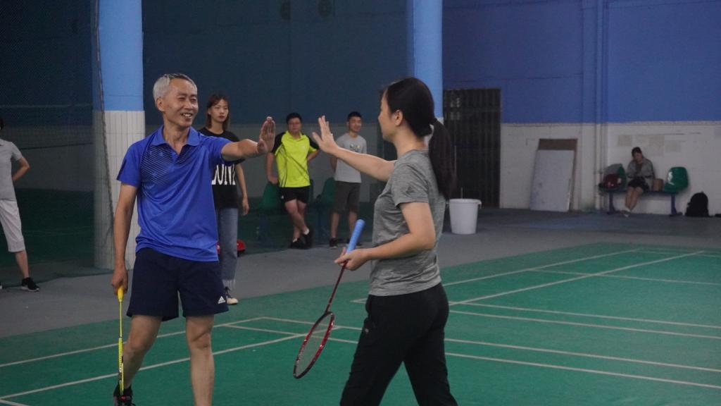 刘书记(右一)和付经理(右二)在比赛赢球时击掌